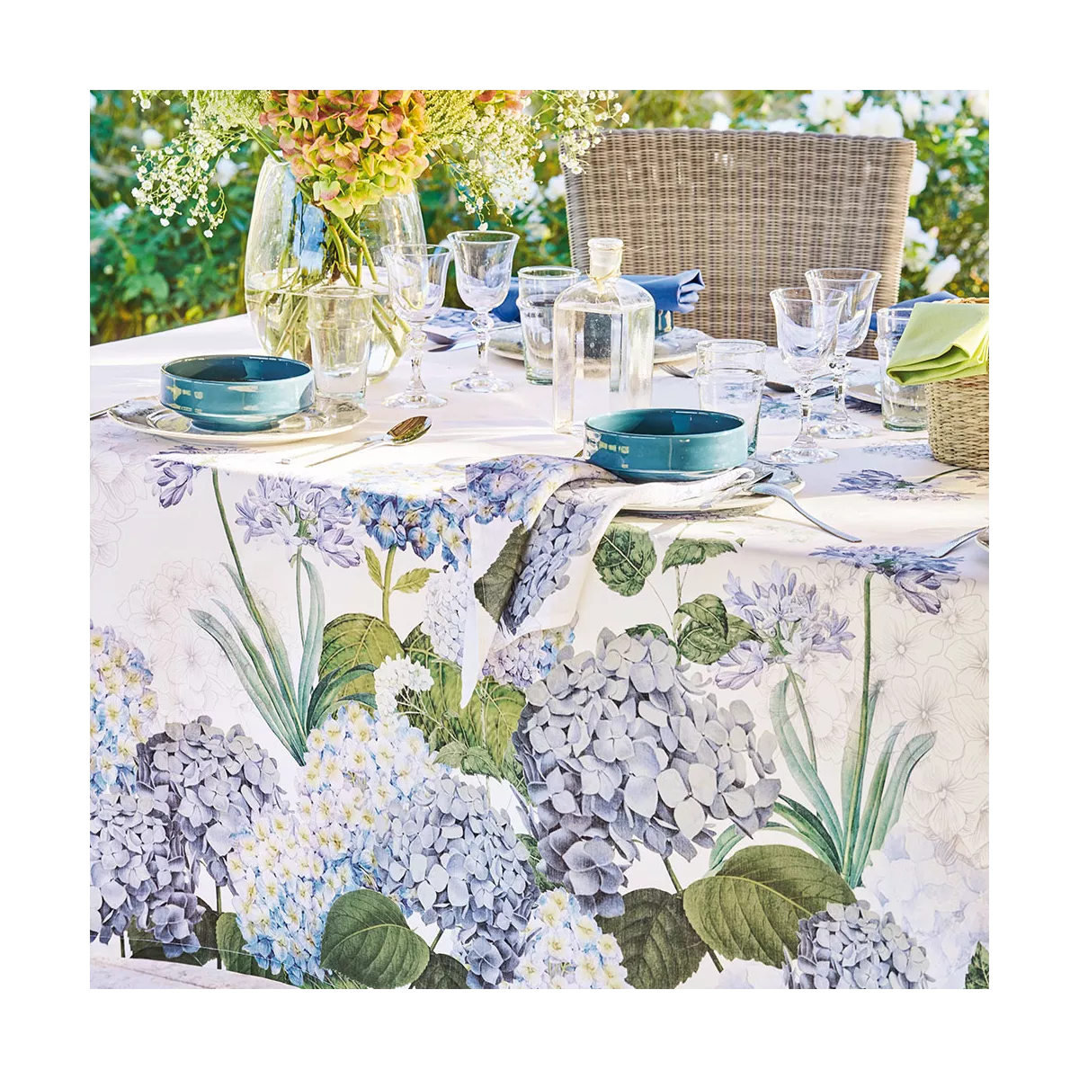 Tischdecke in Weiß mit Hortensienmotiv aus Halbleinen Jardin de Bretagne Bleu von Garnier Thiebaut auf einem Gartentisch