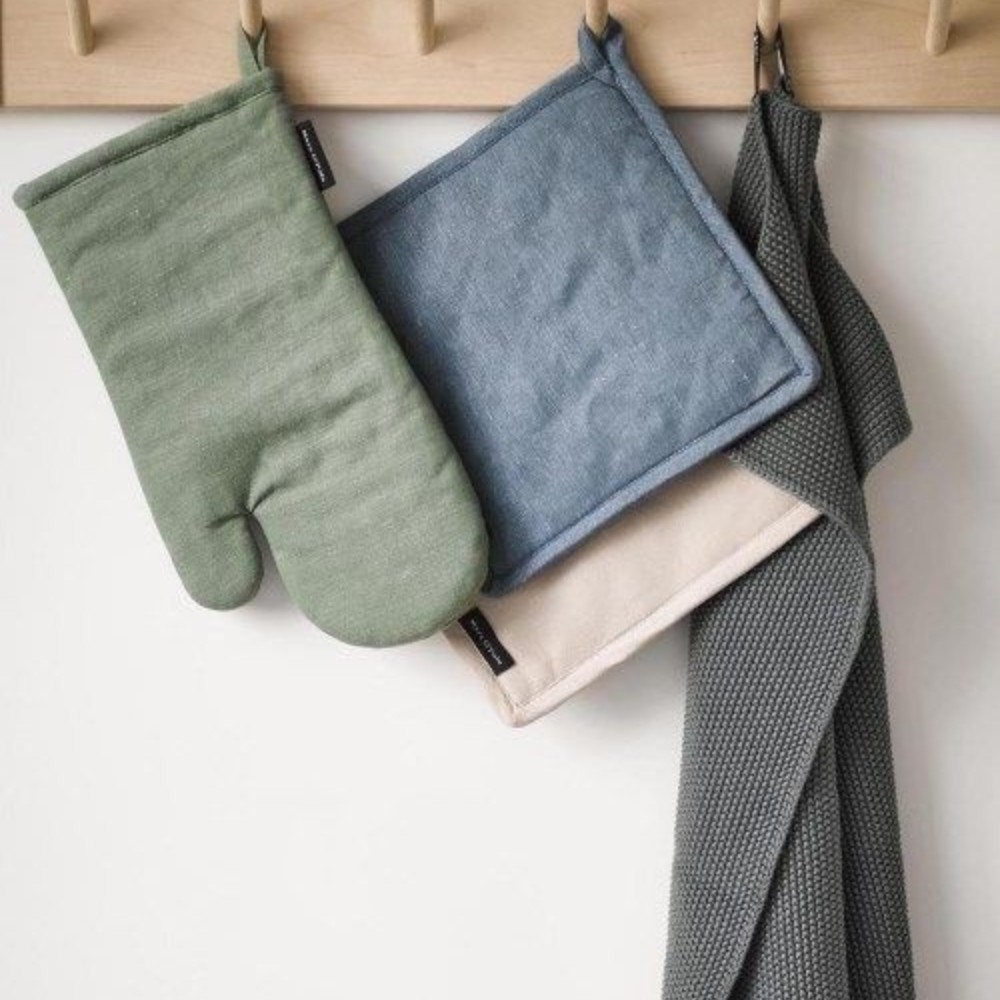 Marc O'Polo Topflappen Akkalla Smoke Blue zusammen mit Ofenhandschuh und Geschirrtuch an einer Küchenleiste
