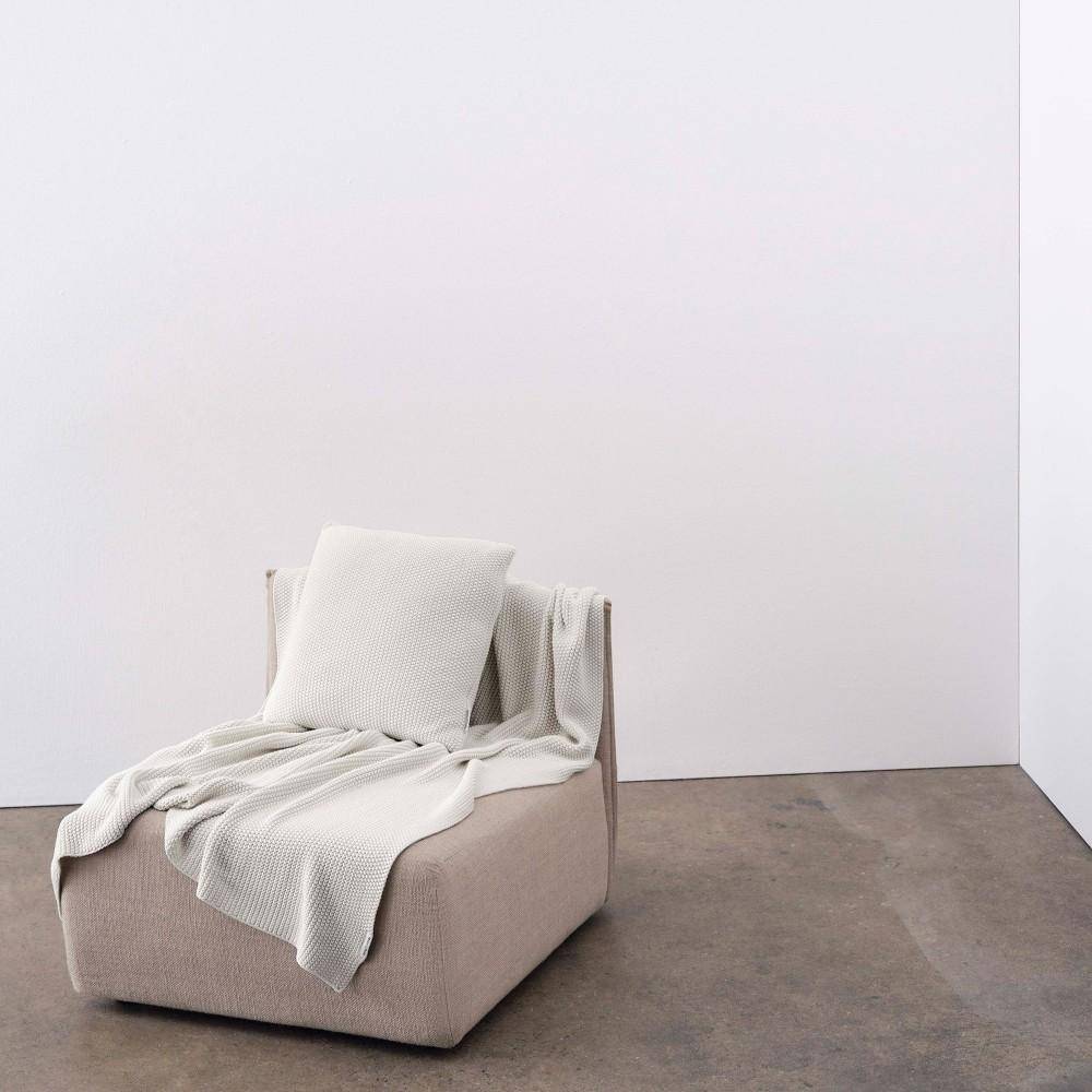 Marc O'Polo Dekokissen Nordic Knit Off White auf Sessel mit Strickdecke im minimalistischen Wohnstil