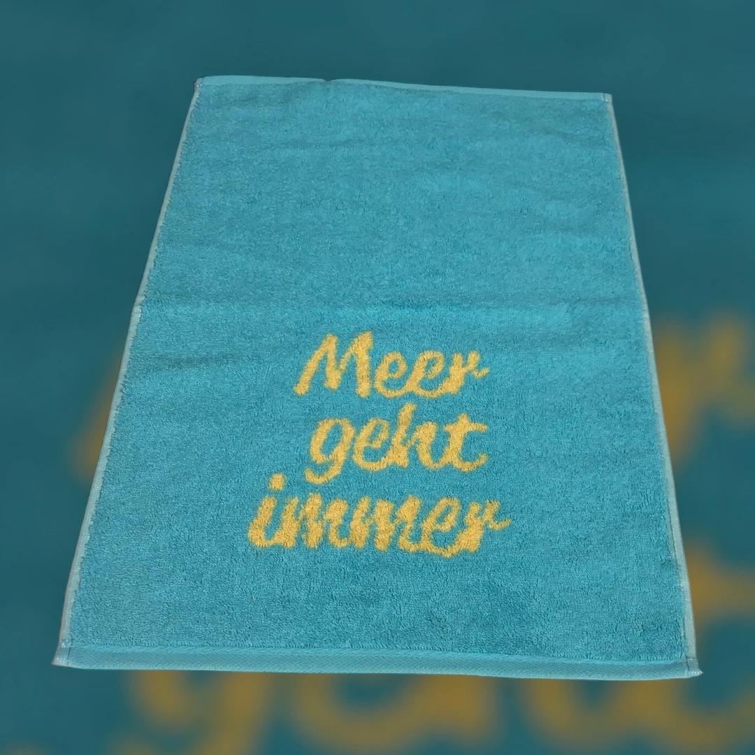 türkisfarbenes Gästetuch von Cawö mit Schriftzug Meer geht immer in gelb