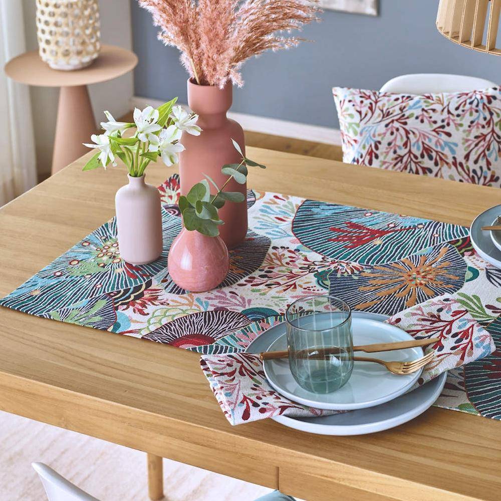 Sander Tischset Sea Flowers mit maritimem Jacquard-Design auf gedecktem Holztisch mit Geschirr und Vasen