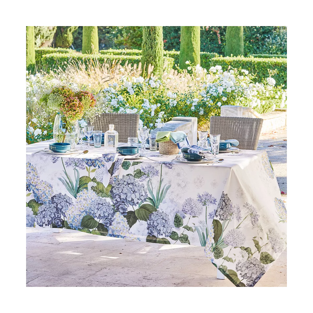 Tischdecke in Weiß mit Hortensienmotiv aus Halbleinen Jardin de Bretagne Bleu von Garnier Thiebaut auf einem Gartentisch