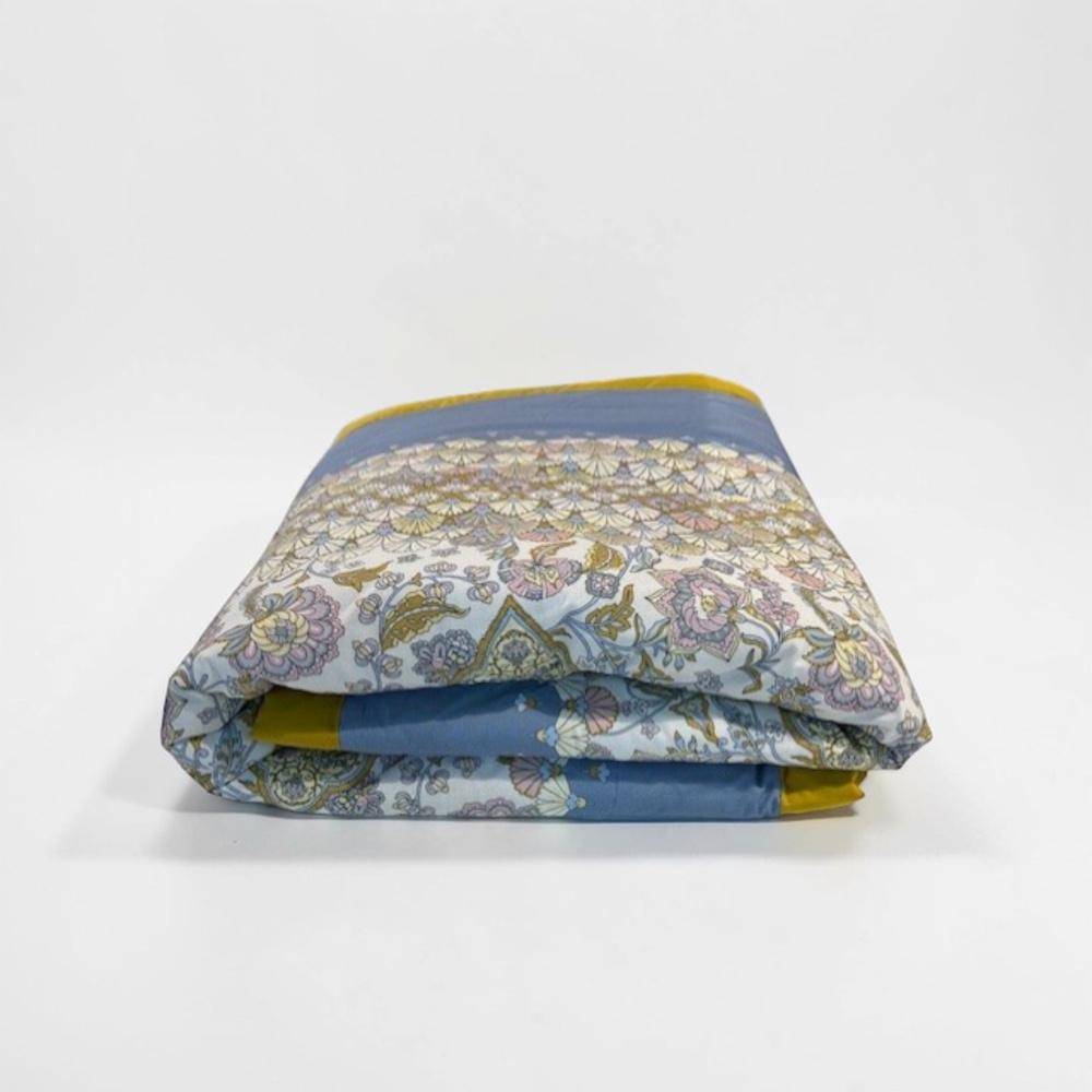 Bassetti Plaid Tigullio C1 in Iceblue mit dekorativem floralen Muster und goldgelber Bordüre, locker gefaltet auf neutralem Hintergrund