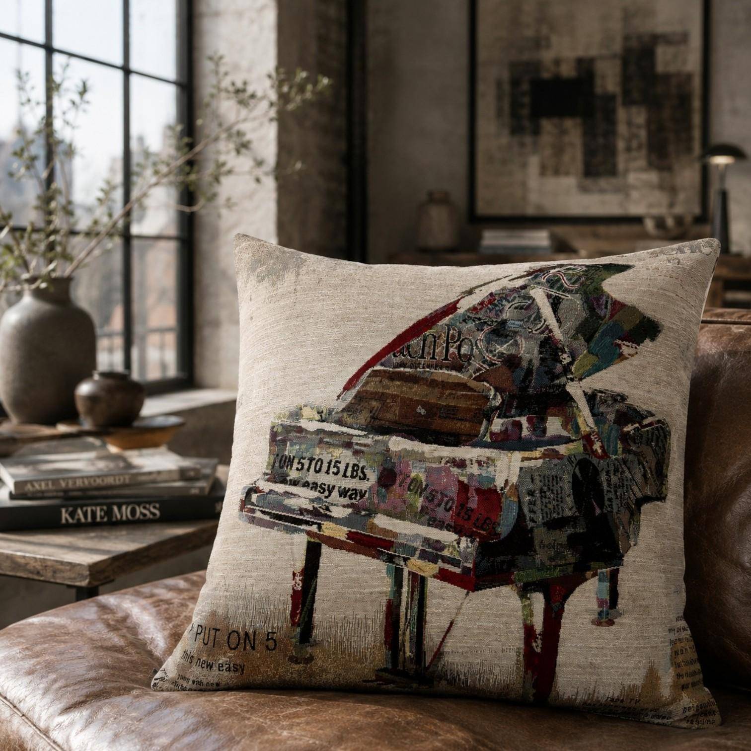 Moderne Sandner Kissenhülle mit buntem Flügel-Motiv aus Gobelin auf braunem Ledersofa im urbanen Loft-Wohnstil